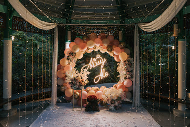 Romantic Outdoor Proposal Decor at One North Park Pavilion in Singapore with Round Balloon Arch, Marry Me Neon Signage, Overhead Fairylights and Flowers by Style It Simply